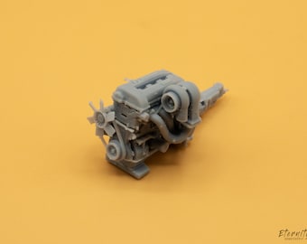 May include: A gray plastic model of a car engine with a fan and intake manifold.