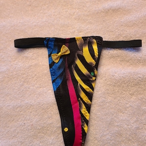 May include: Black, yellow, blue, and pink patterned underwear with a yellow bow.