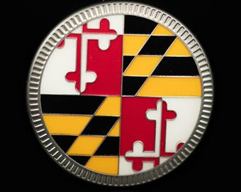 Può includere: Spilla rotonda color argento con un design dettagliato. Presenta l'emblema della bandiera del Maryland, un motivo diviso in quattro parti rosse, bianche, nere e gialle. Ha un bordo strutturato e uno sfondo nero.