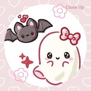 以下が含まれることがあります： コウモリと幽霊の漫画イラスト。 コウモリは灰色の翼と笑顔で、幽霊はピンクのリボンをしています。 背景は、ハートと「Close Up」の文字が入った薄いピンク色です。