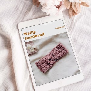 May include: A digital tablet displaying a knitting pattern for a waffle headband. The pattern is titled "Waffle Headband" and the designer is "whljberry". The headband is a dusty rose colour and is shown on a white background.