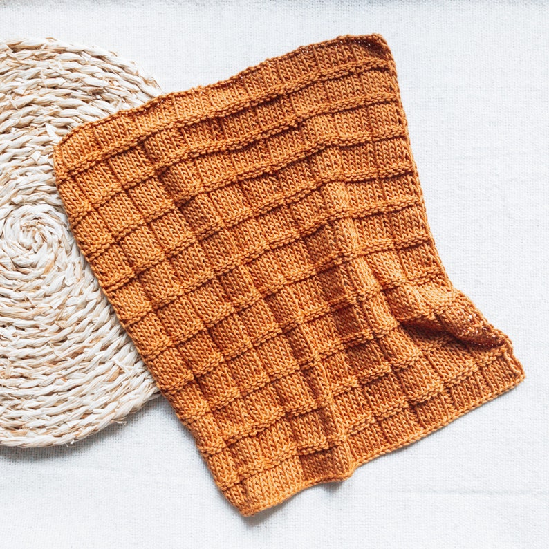 May include: A mustard yellow knitted throw blanket with a waffle stitch pattern.