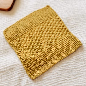 May include: A yellow knitted dishcloth with a textured pattern.