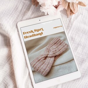 May include: A digital tablet displaying a knitting pattern for a pink headband titled "Fresh Start Headband" by "whistleberry".