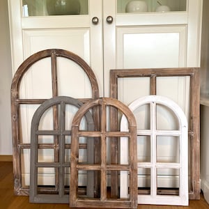 Könnte beinhalten: Vier Holzrahmen mit Bogenfenstern in verschiedenen Größen und Farben. Die Rahmen sind aus verwittertem Holz mit rustikalem Finish. Die Rahmen sind in einer Reihe auf einem Holzboden angeordnet.