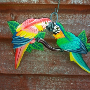 Parrot wall art handmade in Haiti from old oil drums. There is a hook on the back to allow these beautiful birds to be hung on any wall, gate, fence or door. Hand painted by Haitian artists. These colourful metal birds make a great housewarming gift