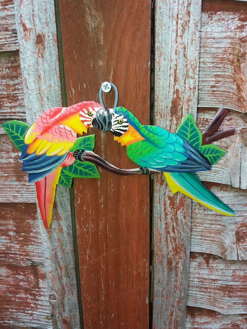 Parrot wall art handmade in Haiti from old oil drums. There is a hook on the back to allow these beautiful birds to be hung on any wall, gate, fence or door. Hand painted by Haitian artists. These colourful metal birds make a great housewarming gift