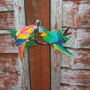 Parrot wall art handmade in Haiti from old oil drums. There is a hook on the back to allow these beautiful birds to be hung on any wall, gate, fence or door. Hand painted by Haitian artists. These colourful metal birds make a great housewarming gift