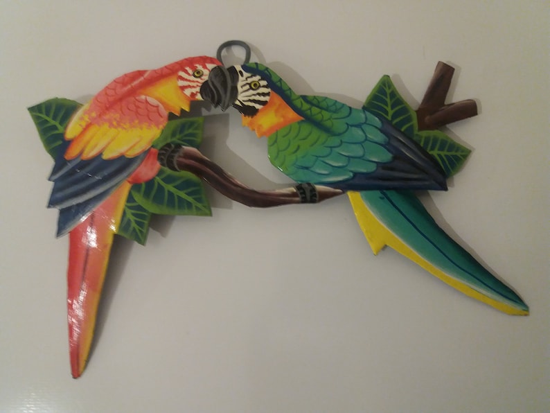 Parrot wall art handmade in Haiti from old oil drums. There is a hook on the back to allow these beautiful birds to be hung on any wall, gate, fence or door. Hand painted by Haitian artists. These colourful metal birds make a great housewarming gift