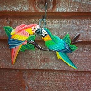 Parrot wall art handmade in Haiti from old oil drums. There is a hook on the back to allow these beautiful birds to be hung on any wall, gate, fence or door. Hand painted by Haitian artists. These colourful metal birds make a great housewarming gift
