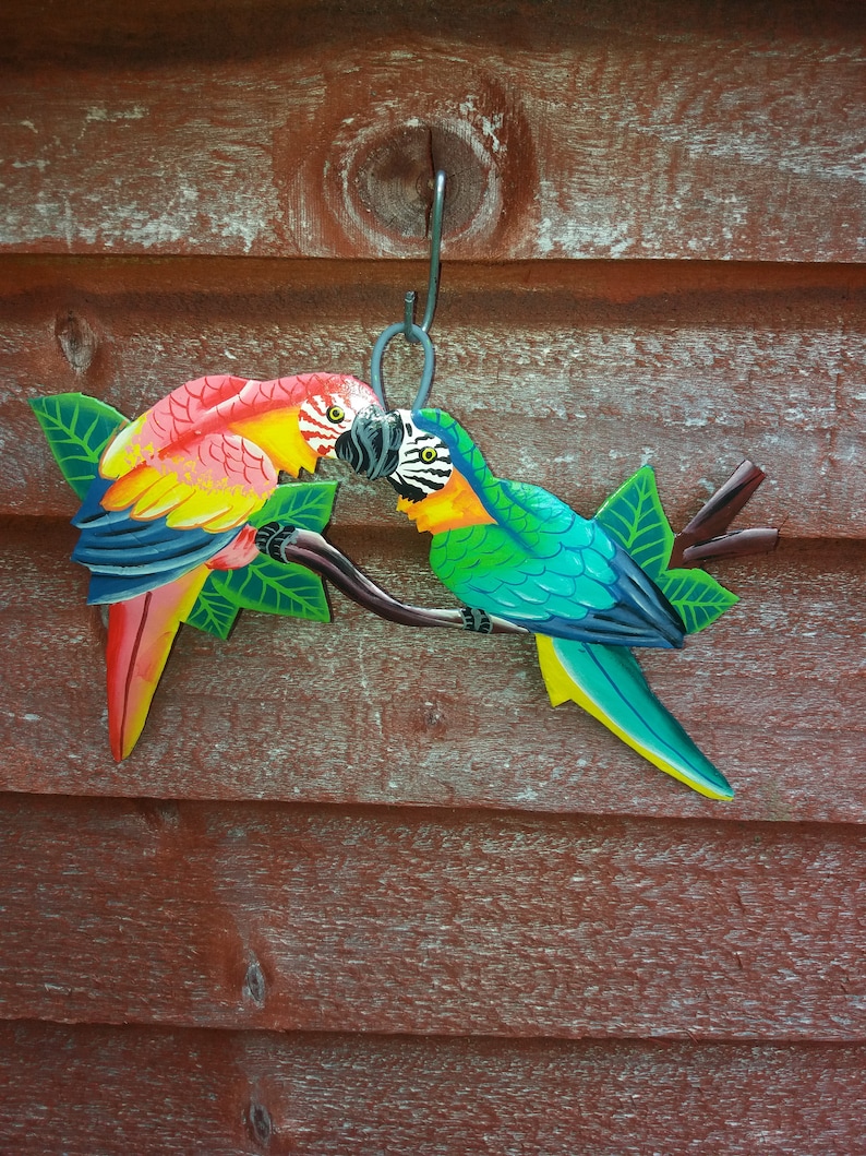 Parrot wall art handmade in Haiti from old oil drums. There is a hook on the back to allow these beautiful birds to be hung on any wall, gate, fence or door. Hand painted by Haitian artists. These colourful metal birds make a great housewarming gift