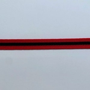 May include: A red elastic band with a central black stripe. The band is made of a woven material and is set against a white background. This trim could be used for clothing or accessories.