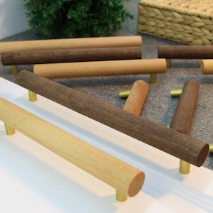 Puede incluir: Surtido de pomos de armario de madera con herrajes de latón en acabados de madera natural y oscura.