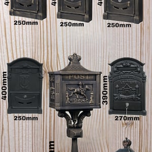 Może przedstawiać: Kolekcja skrzynek pocztowych w stylu antycznym, wykonanych z ciemnego metalu. Projekty obejmują skrzynkę z jeźdźcem i koniem oraz inne z elementami dekoracyjnymi. Wymiary wahają się od 40 cm do 111 cm wysokości i od 25 cm do 38 cm szerokości.