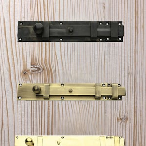 May include: Four door bolt locks in different finishes: silver, black, brass, and gold. The bolts are all the same size and shape, but have different finishes.