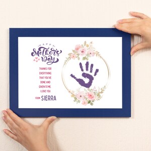May include: A blue framed print with a handprint in a floral wreath. The text reads "Happy Mother's Day" and "Thanks for everything that you've done and given to me. I love you. From Sierra."