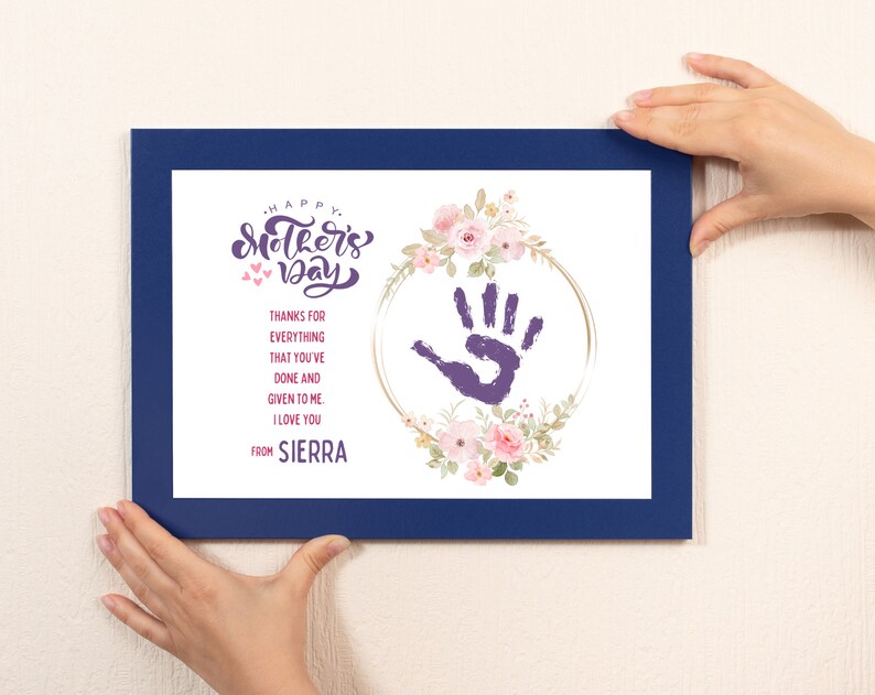 May include: A blue framed print with a handprint in a floral wreath. The text reads "Happy Mother's Day" and "Thanks for everything that you've done and given to me. I love you. From Sierra."