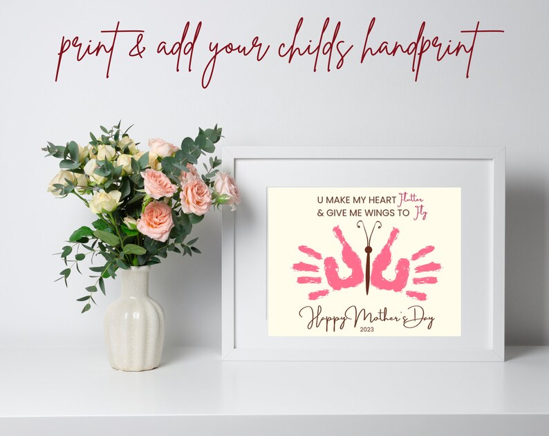 May include: A framed print with a pink butterfly made from handprints. The text reads "U make my heart flutter & give me wings to fly" and "Happy Mother's Day 2023".