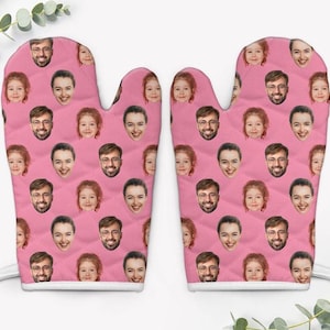 May include: A pair of pink oven mitts with a repeating pattern of faces. The faces are of different people, including adults and children.