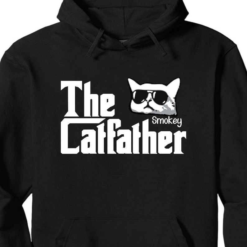 May include: Black hooded sweatshirt with a white graphic of a cat wearing sunglasses and the text "The Catfather" with the name "Smokey" under the cat.