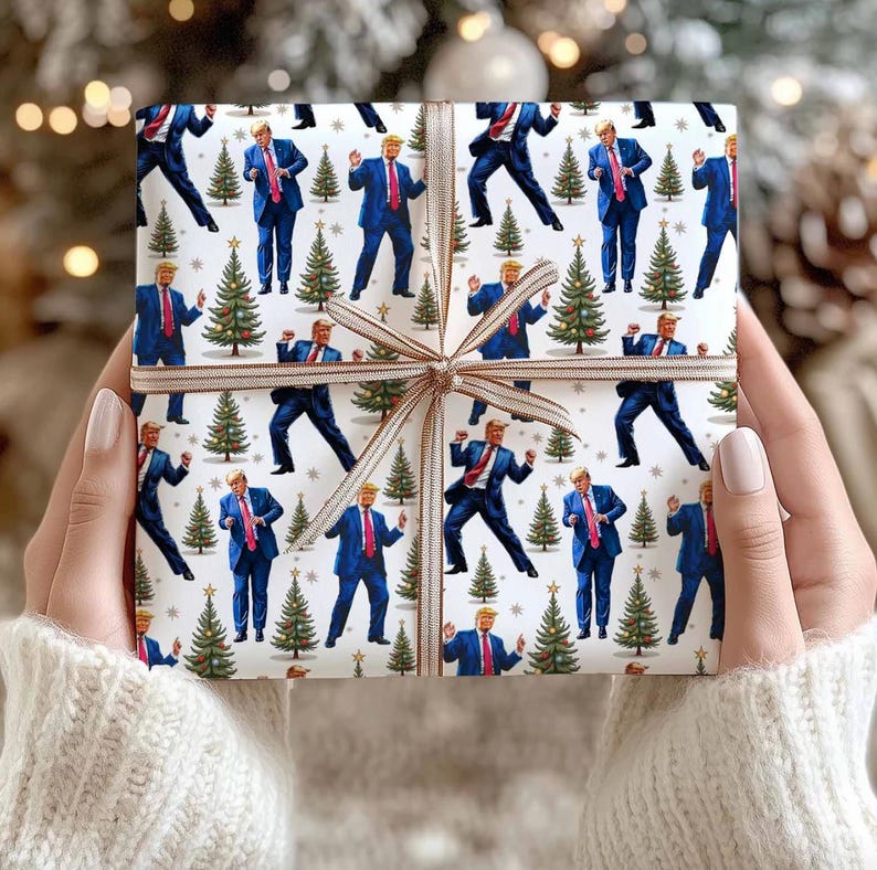 May include: A wrapped gift with white wrapping paper featuring a repeating pattern of a man in a blue suit and Christmas trees. The gift is tied with a brown ribbon.