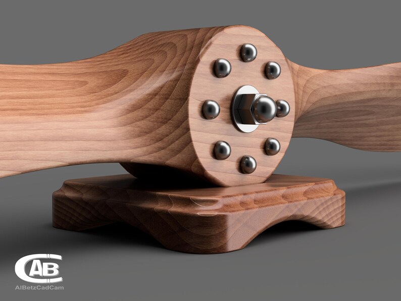 May include: A wooden airplane propeller with a silver metal hub and eight silver metal screws. The propeller is mounted on a wooden base.