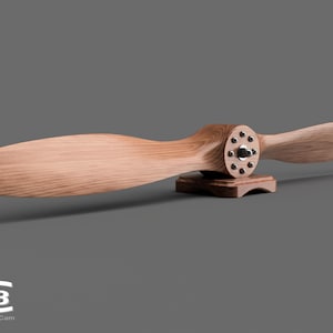 May include: A wooden airplane propeller with a metal hub and a wooden base. The propeller is mounted on the base and is ready to be displayed.