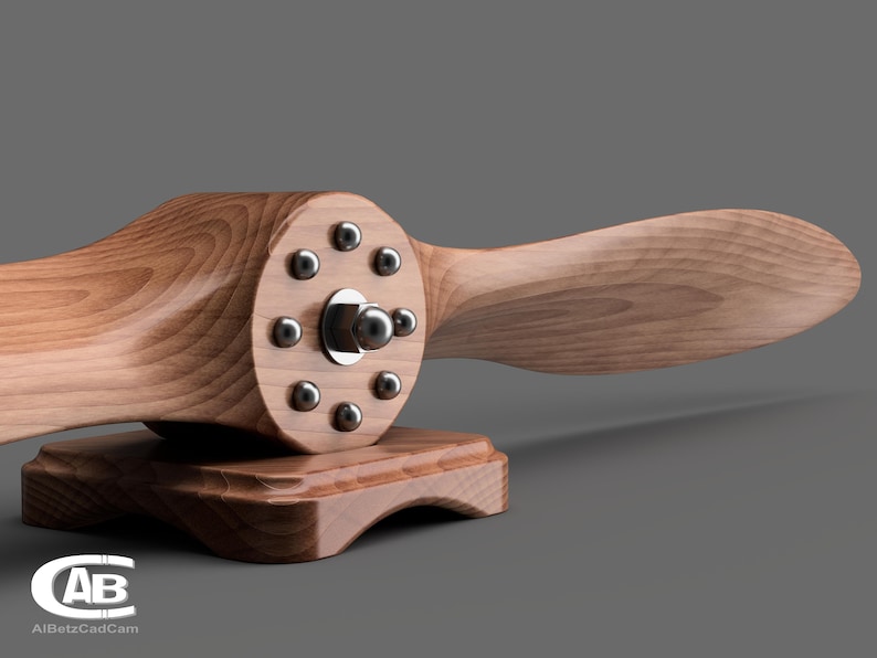 May include: A wooden airplane propeller with a metal hub and 10 screws. The propeller is mounted on a wooden base.