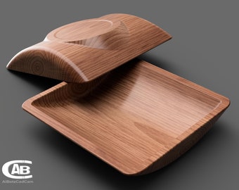 May include: A wooden serving tray with a lid. The tray is rectangular and has a slightly curved edge. The lid is also slightly curved and has a small indentation in the center. The wood is a light brown color and has a natural grain pattern.