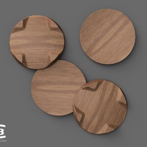 Puede incluir: Cuatro posavasos redondos de madera, tres con un dise&ntilde;o en forma de estrella y uno liso. Los posavasos est&aacute;n dispuestos en un grupo sobre un fondo gris.
