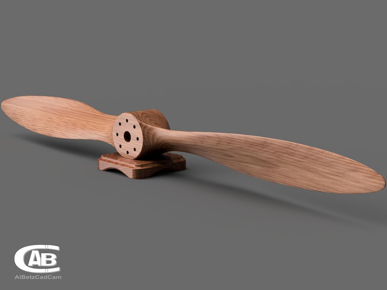 May include: A wooden airplane propeller with a brown finish, mounted on a wooden base. The propeller has a circular hub with multiple holes.