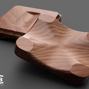 May include: Two wooden trays, one with a curved, indented surface and the other with a flat surface. The trays are made of light brown wood with a natural grain pattern.