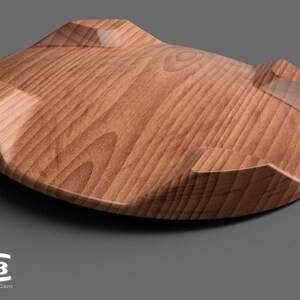 Puede incluir: Un posavasos de madera con una parte superior redondeada, ligeramente c&oacute;ncava y tres bordes elevados. El posavasos tiene un patr&oacute;n de veta de madera natural y un acabado brillante.