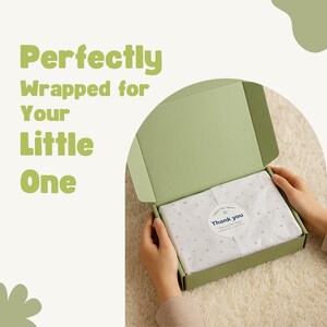 Op de afbeelding: Een open, lichtgroene doos met de tekst "Perfectly Wrapped for Your Little One". Binnenin is een pakket verpakt in wit papier met een sterrenpatroon en een "Thank you" sticker.