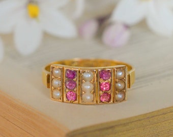 May include: A gold ring with a row of pink stones and a row of white pearls on each side.