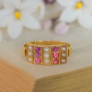 Peut inclure: Une bague en or avec une rangée de pierres roses et une rangée de perles blanches de chaque côté.