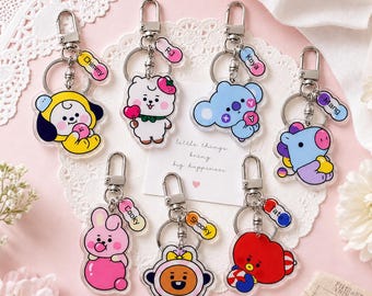 May include: Seven acrylic keychains featuring colorful cartoon characters including a yellow dog, white alpaca, blue koala, purple horse, pink rabbit, orange cookie, and red heart, each with a silver lobster clasp and a small name tag attached.
