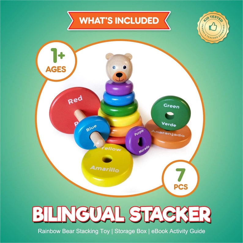 Puede incluir: Un juguete de apilar de madera colorido con una cabeza de oso en la parte superior. Los anillos est&aacute;n etiquetados con colores en ingl&eacute;s y espa&ntilde;ol. El juguete est&aacute; dise&ntilde;ado para ni&ntilde;os de 1 a&ntilde;o en adelante. El texto en la imagen dice "What's Included", "Kid Tested Parent & Teacher Approved", "1+ Ages", "Red", "Blue", "Yellow", "Amarillo", "Purple", "Morado", "Green", "Verde", "Anaranjado", "7 PCS", "Bilingual Stacker", "Rainbow Bear Stacking Toy | Storage Box | eBook Activity Guide".