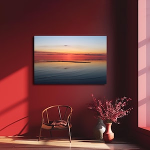 May include: A photograph of a sunset over a calm body of water. The sky is a mix of orange, pink, and purple, and the water is reflecting the colors of the sky. There is a small island in the distance.