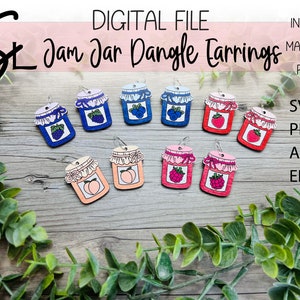 Pode incluir: Oito pares de brincos pendentes com um design de pote de geleia com diferentes recheios de frutas. Os brincos são feitos de madeira e têm um acabamento pintado. Os recheios de frutas incluem mirtilos, morangos e pêssegos.