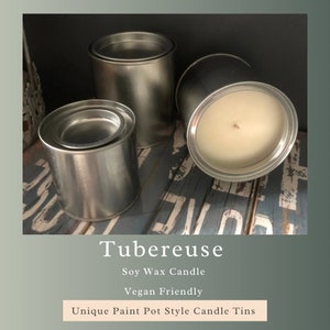 May include: Three silver paint can style candle tins. The largest tin has a white soy wax candle inside. The text "Tubereuse Soy Wax Candle Vegan Friendly Unique Paint Pot Style Candle Tins" is below the image.