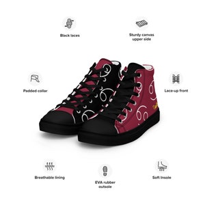 May include: A pair of high-top canvas sneakers with a burgundy and black color scheme. The shoes feature a white swirl design and black laces. The shoes have a padded collar, breathable lining, and a soft insole.