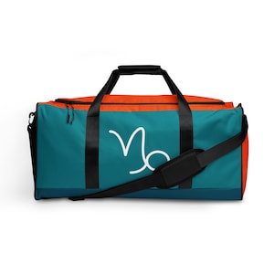 May include: Teal and orange duffel bag with a white Capricorn zodiac symbol on the front.