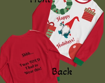 Può includere: Una felpa natalizia rossa e bianca con un design festivo. La parte anteriore presenta una ghirlanda, dei regali e uno gnomo con le parole "Happy Holidays!". Il retro della felpa dice "Shhh... I was TOLD I had to Wear this!"