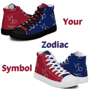 May include: A pair of high-top canvas shoes with a red and blue design featuring the Capricorn zodiac symbol. The shoes have white laces and a black sole.
