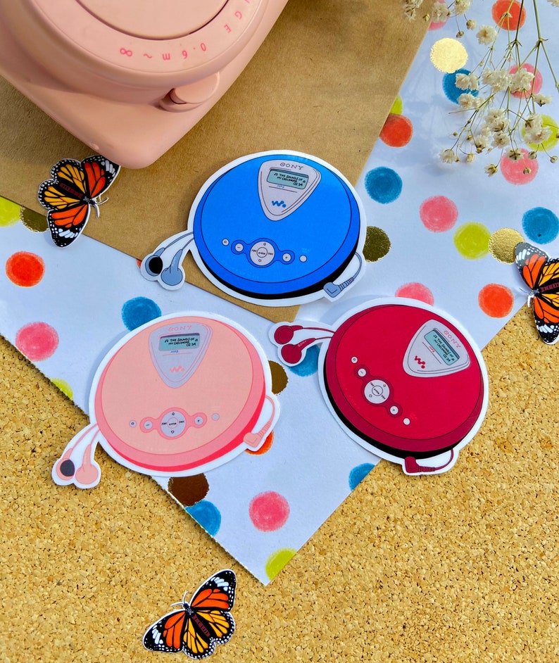 May include: Three colorful stickers of Sony Discman portable CD players with headphones. The stickers are on a white background with colorful polka dots.