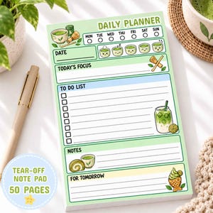 Peut inclure: Un bloc-notes détachable de 50 pages pour la planification quotidienne avec un thème vert clair. La mise en page comprend des sections pour la date, les priorités, la liste de tâches, les notes et demain, illustrées de matcha et snacks.