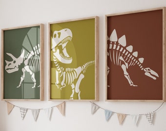 May include: Three framed prints of dinosaur skeletons, each with a different dinosaur. The prints are on a white wall with a string of flags hanging below them.