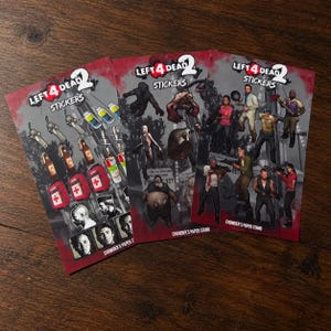 May include: Three rectangular sticker sheets featuring Left 4 Dead 2 branding. The sheets display various game items, including medical kits, weapons, and character illustrations, with the text Left 4 Dead 2 Stickers and Chowder's Paper Stand.