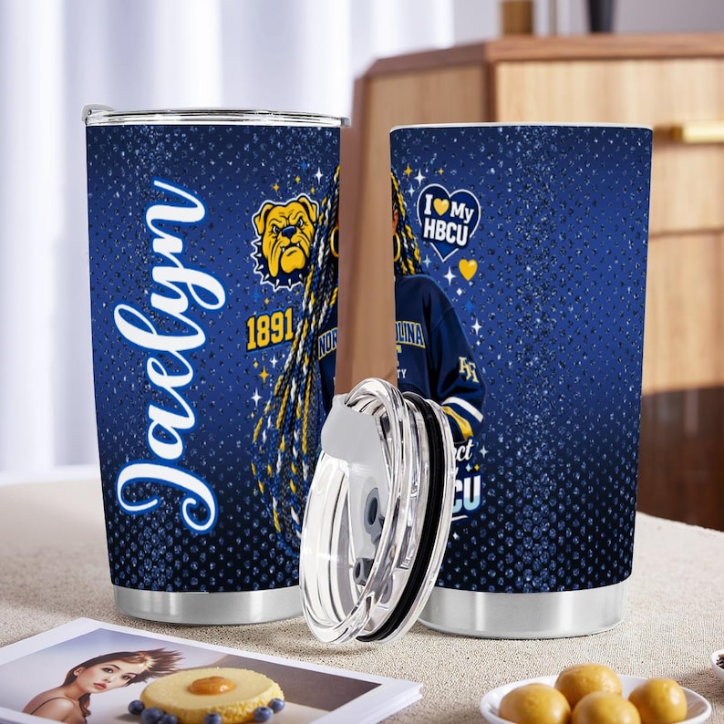 May include: A pair of stainless steel tumblers with a blue background and a design featuring the name "Jaelyn", a bulldog, and the text "I Love My HBCU". One tumbler has a lid removed.